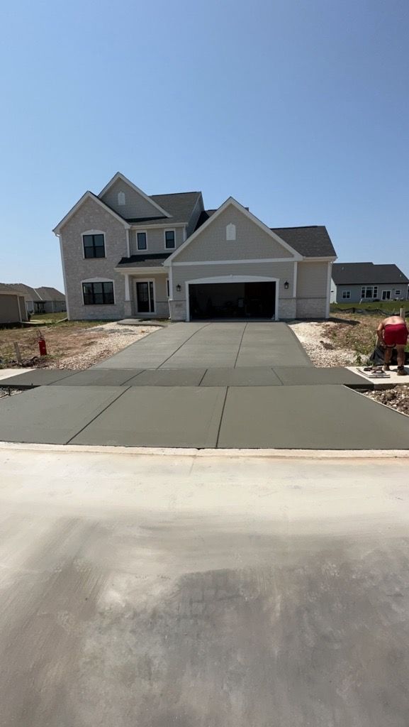 A large house with a concrete driveway in front of it.
