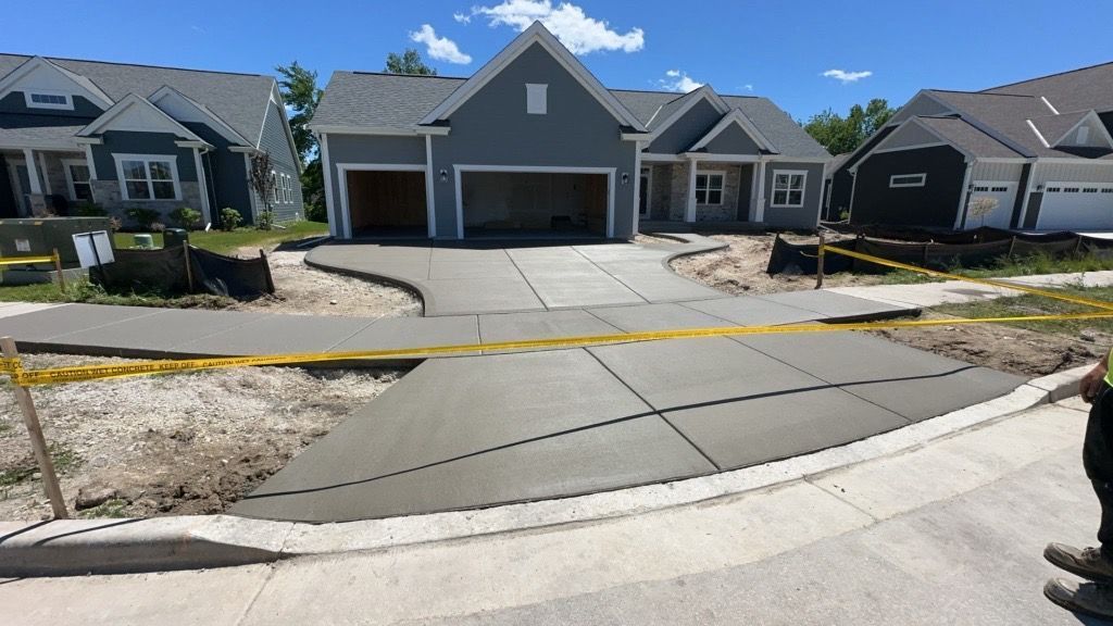 A concrete driveway is being built in front of a house