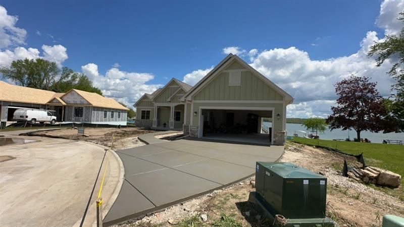 A man is standing in front of a concrete driveway that has been damaged by a bulldozer