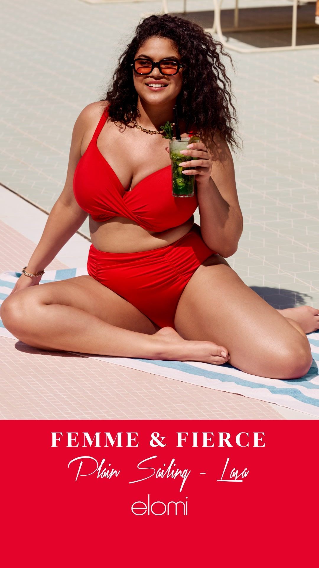 A person sitting on a towel by a pool, wearing a bright red bikini and sunglasses, holding a drink. Elomi brand logo.
