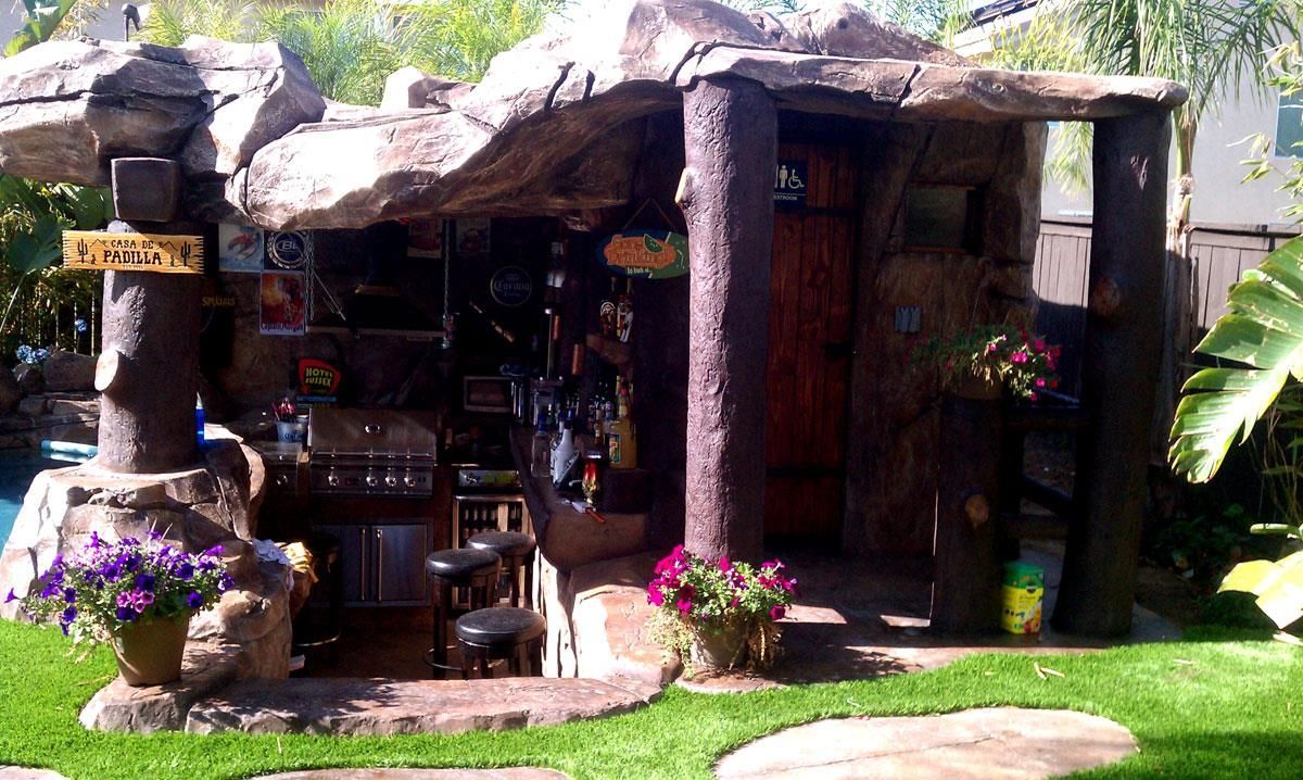 A house that looks like a cave with flowers in front of it