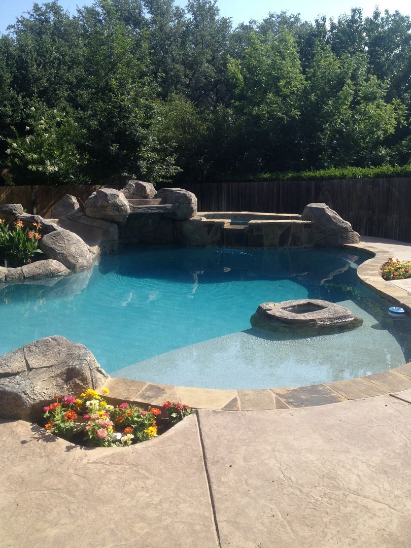 A large swimming pool surrounded by rocks and trees
