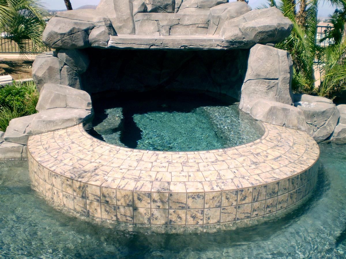 A pool with a waterfall in the middle of it