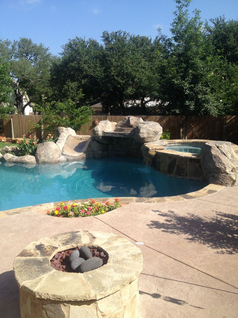 A large swimming pool with a fire pit in front of it