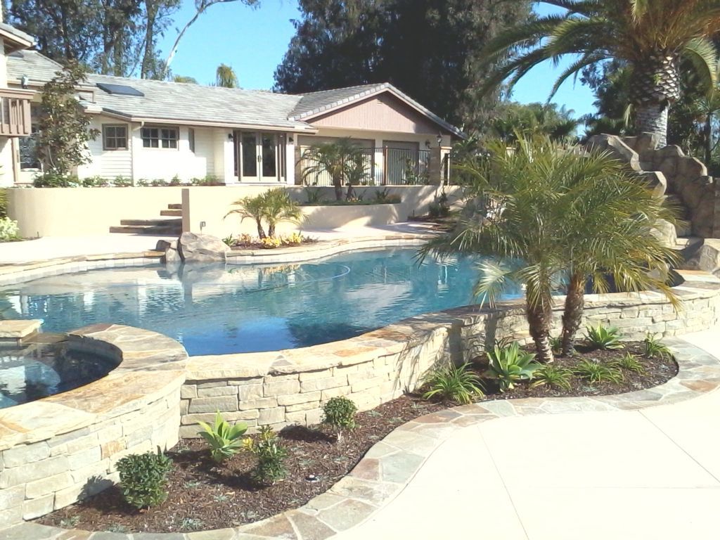 A house with a large swimming pool in front of it