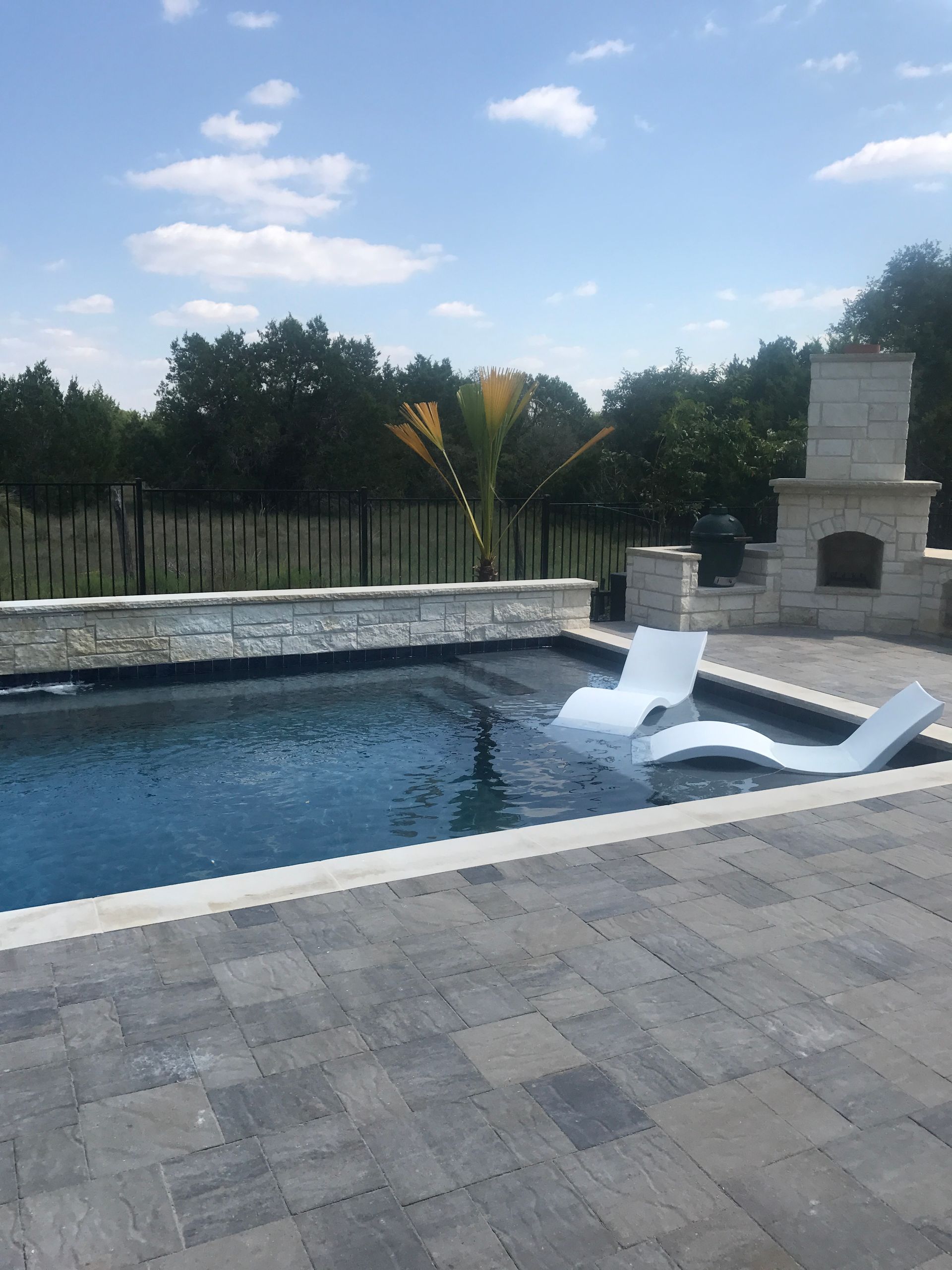 A large swimming pool with a fireplace in the background