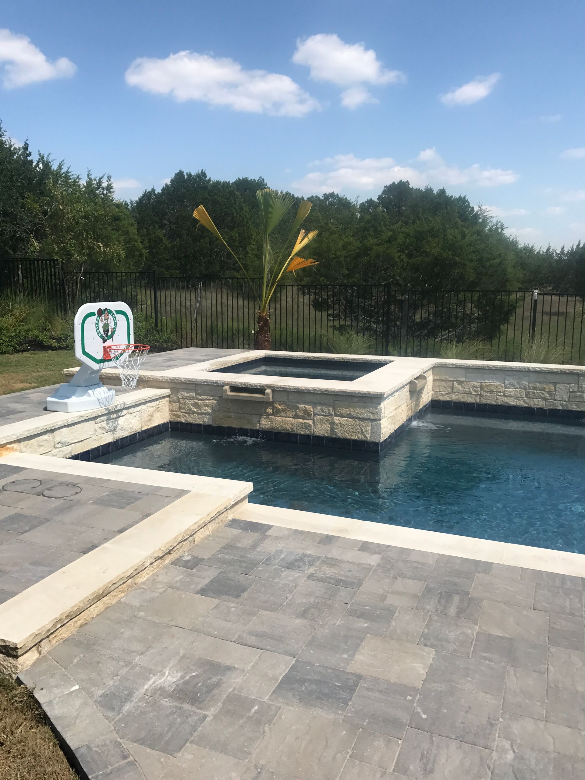 There is a basketball hoop in the middle of the pool.