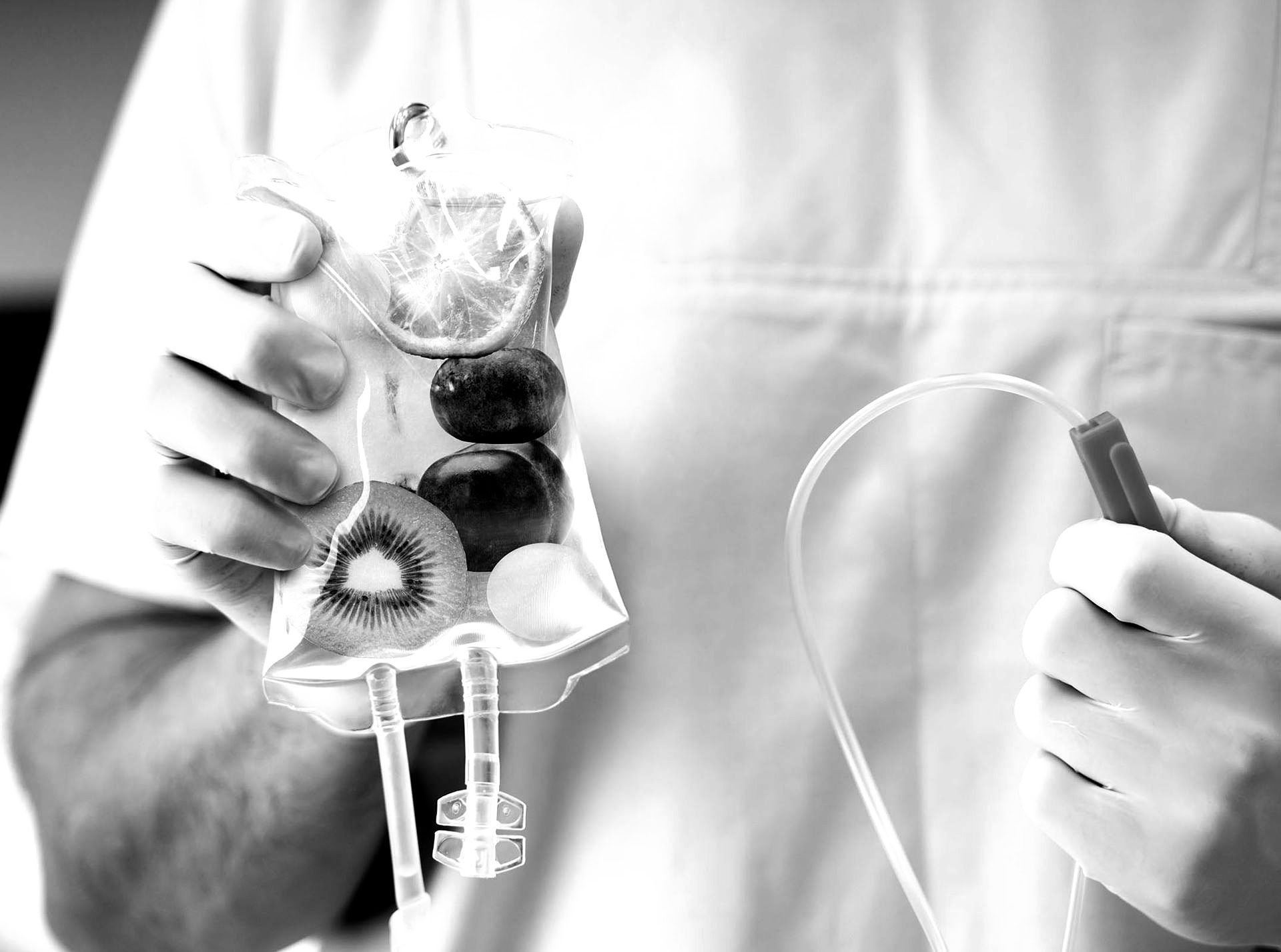 A doctor is holding a bag of fruit in his hands.