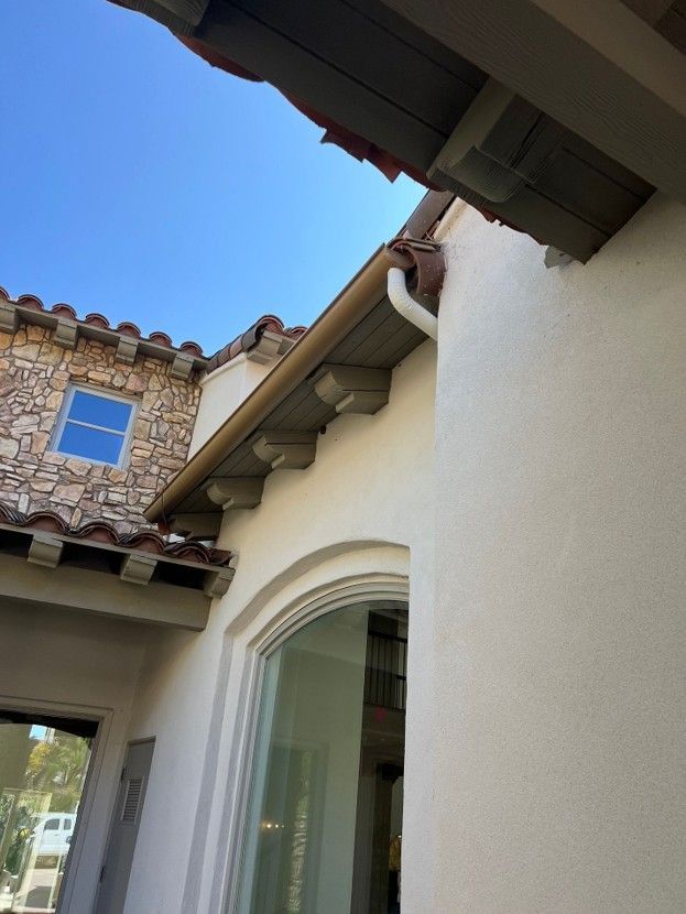Mansion-style courtyard with white stucco walls, terracotta roof tiles, and blue sky overhead