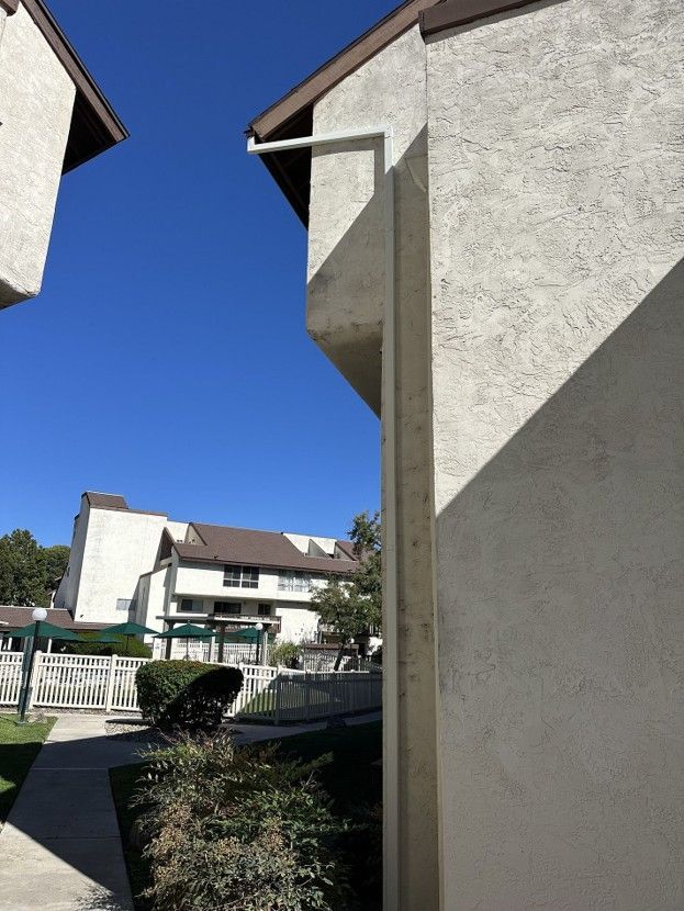 Courtyard view between beige apartment buildings under a clear blue sky