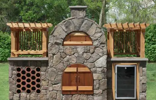 A stone building with wooden doors and shutters is sitting on top of a lush green field.