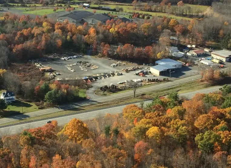 An aerial view of a residential area surrounded by trees and a road