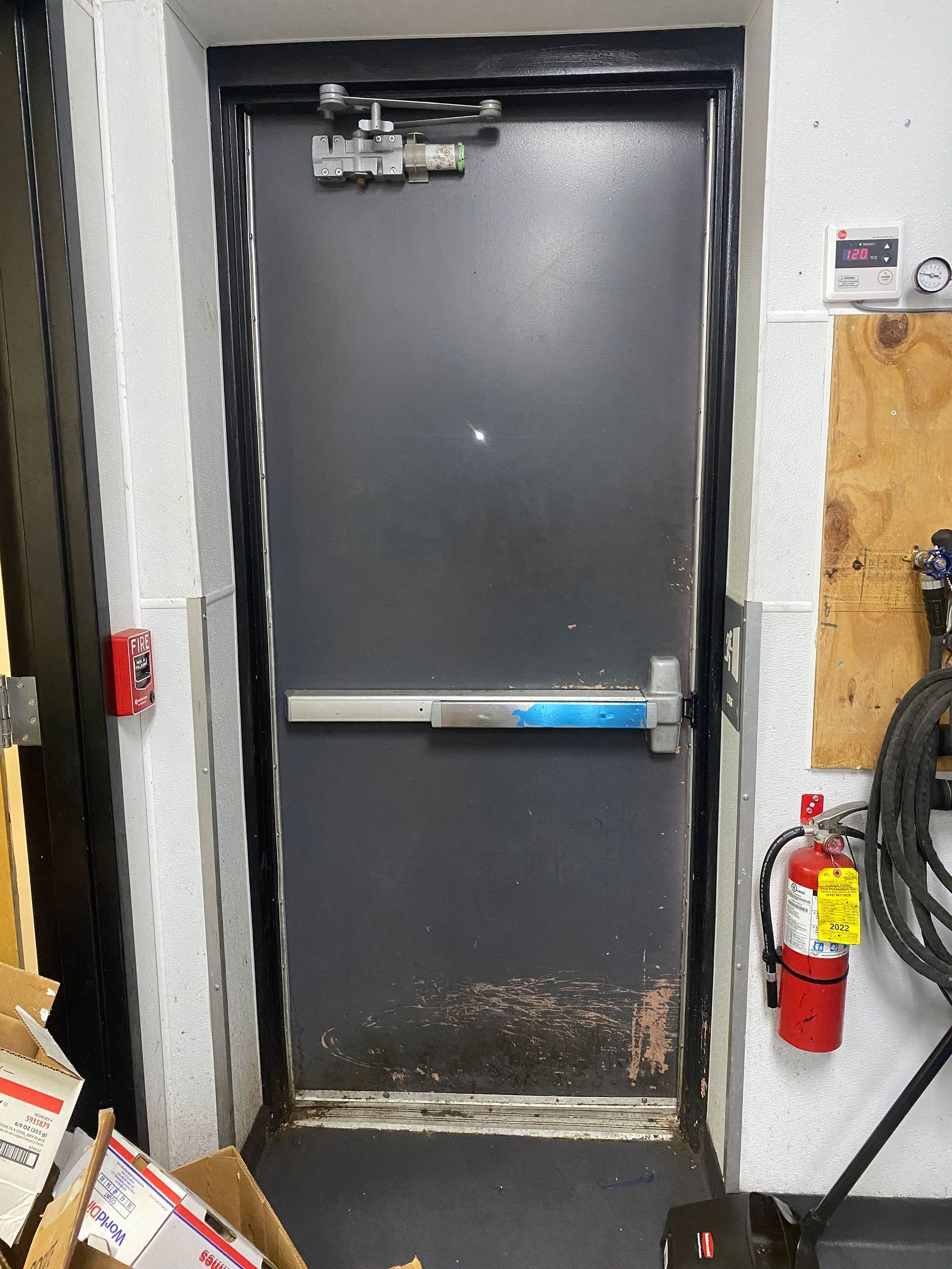 A fire extinguisher is hanging on the wall next to a door