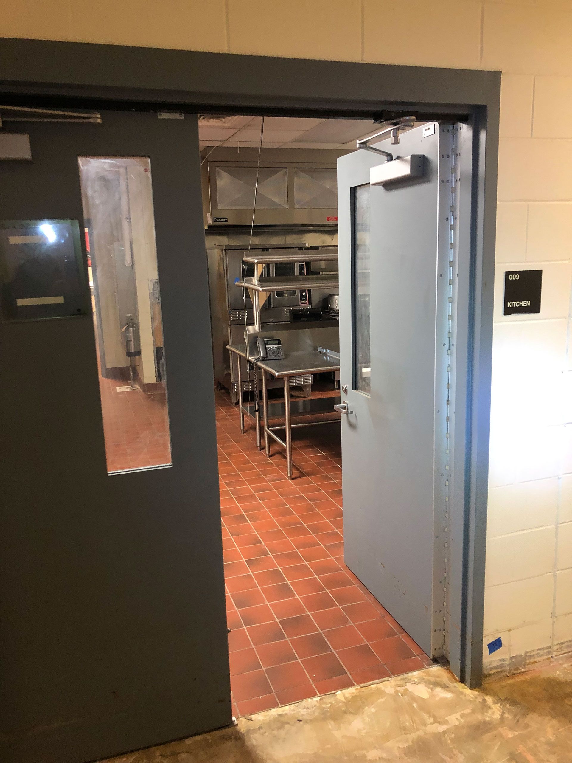 A kitchen with a fireproof door and a window