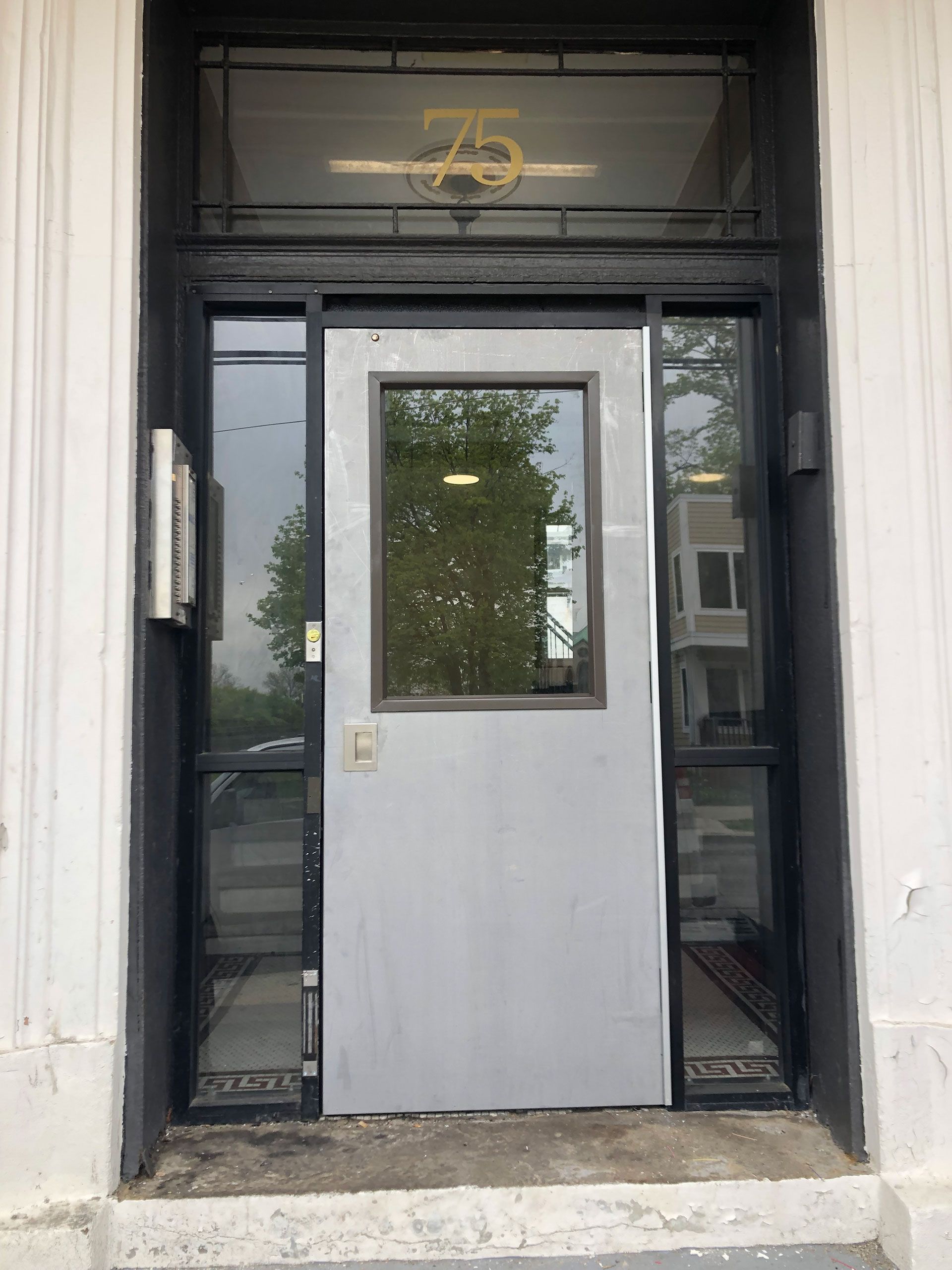 The front door of a building with the number 75 on it