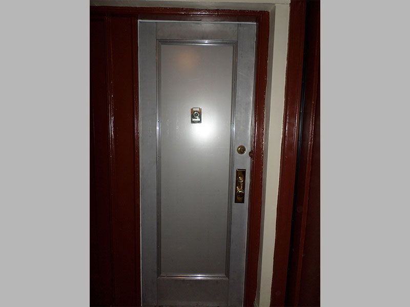 A silver door with a red trim and a gold handle