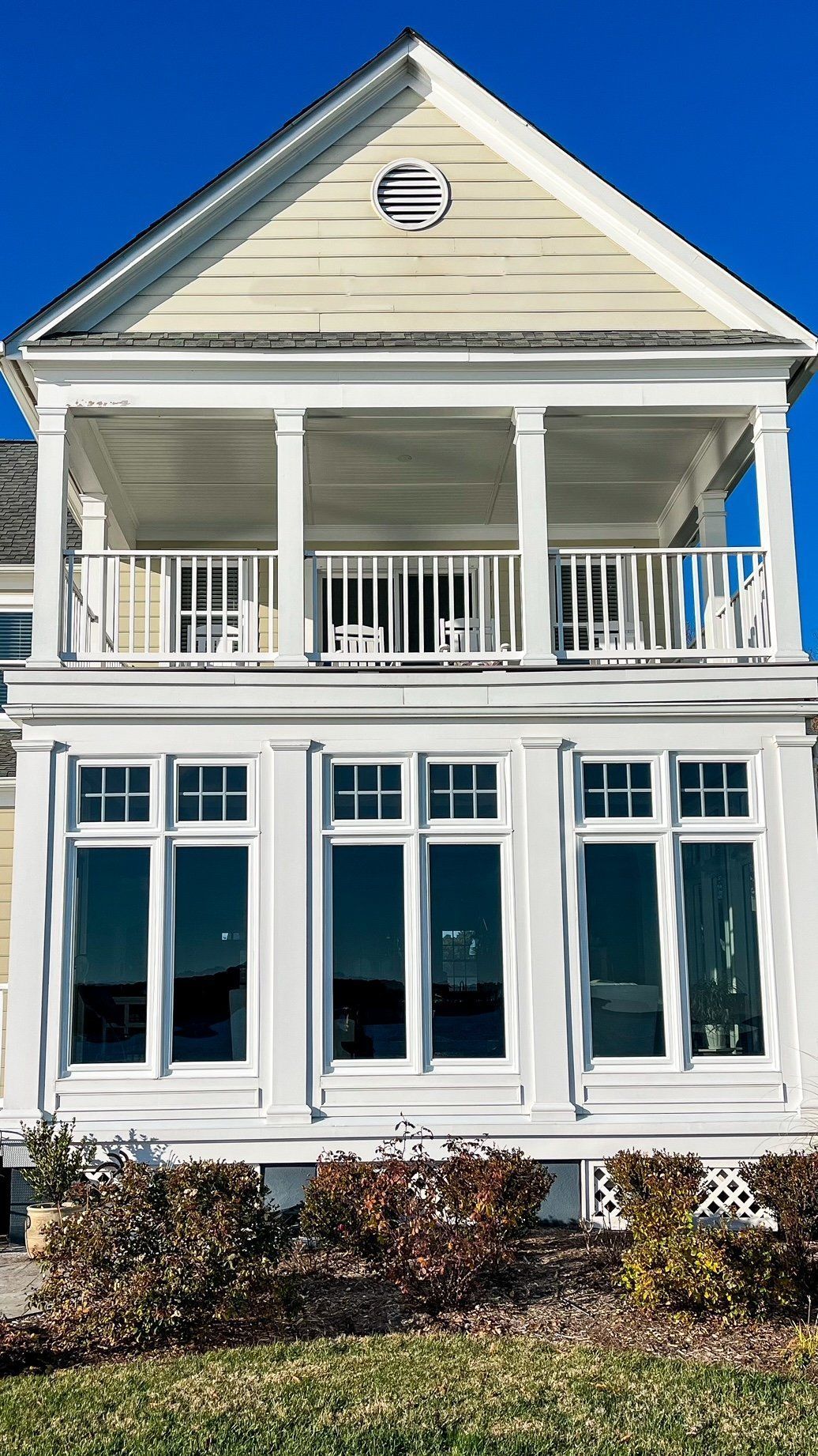 A large white house with a lot of windows and a balcony.