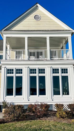 A large white house with a lot of windows and a balcony.