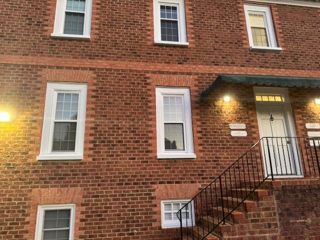 A red brick building with stairs leading up to the front door.