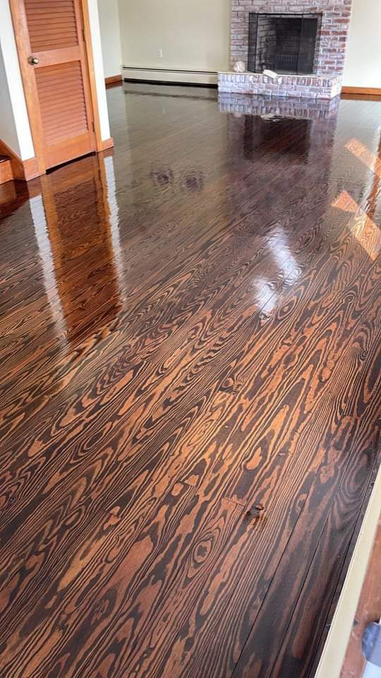 A living room with hardwood floors and a fireplace.