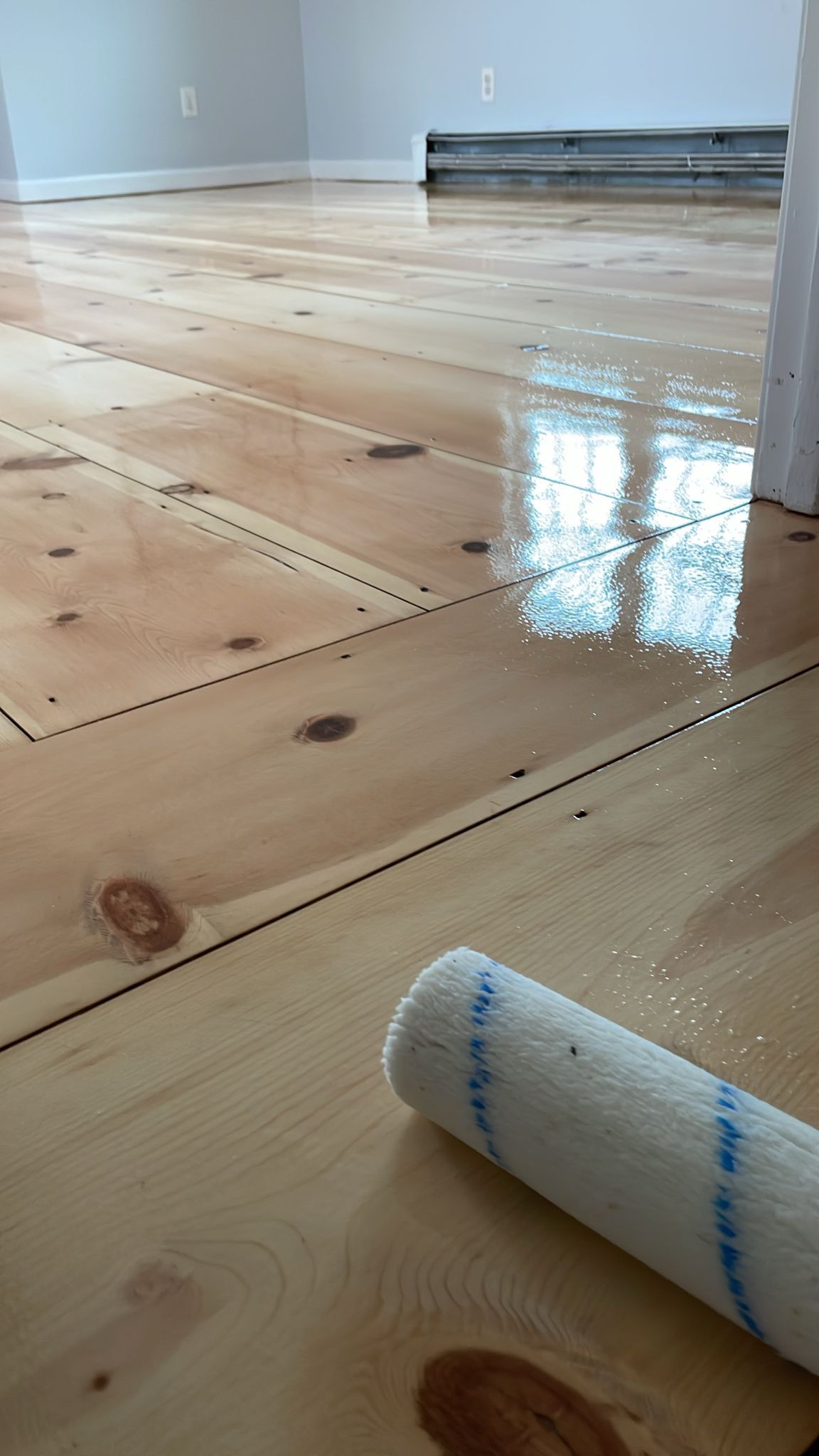 A roller is sitting on top of a wooden floor.