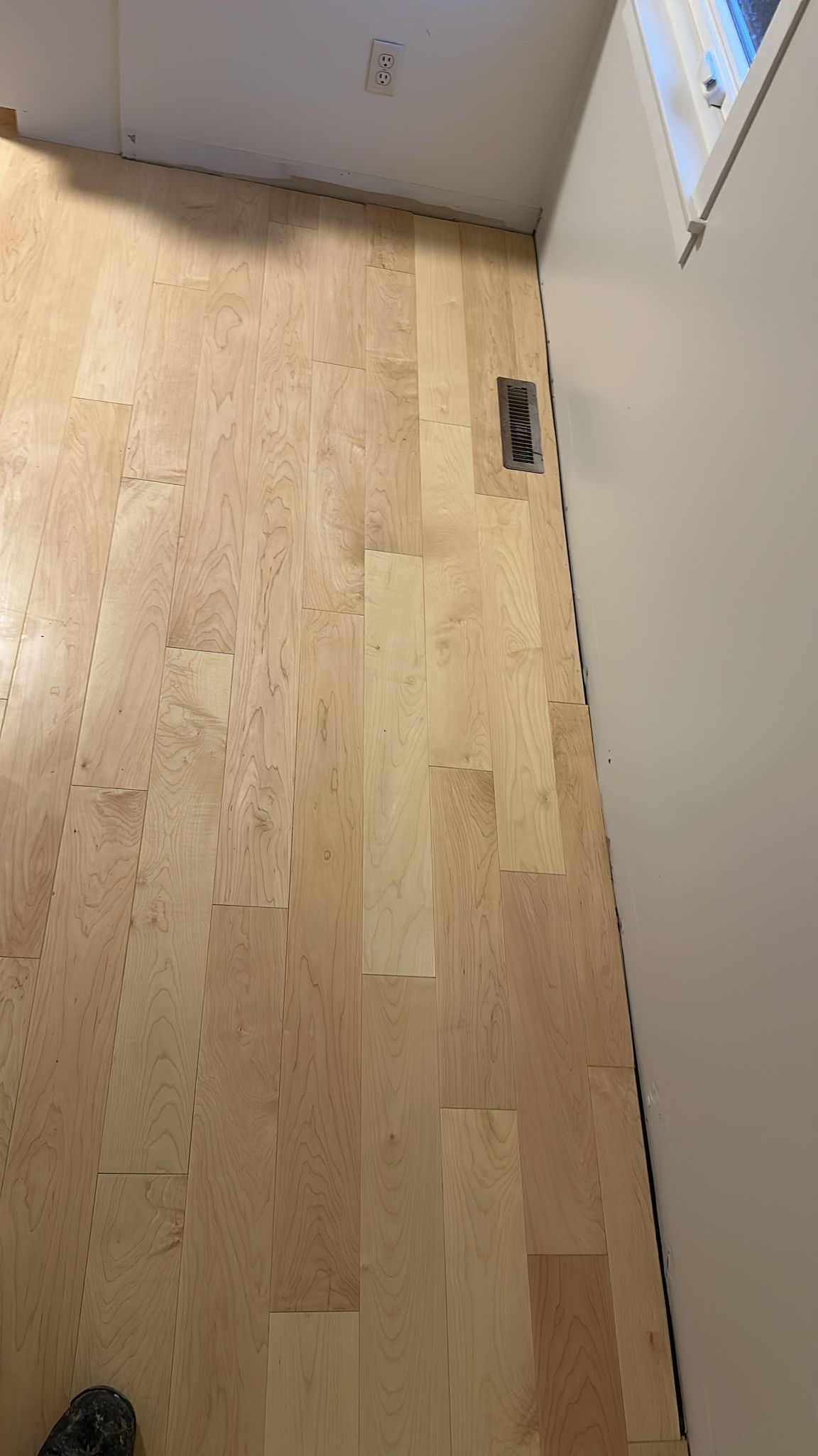 A wooden floor in a room with a window.