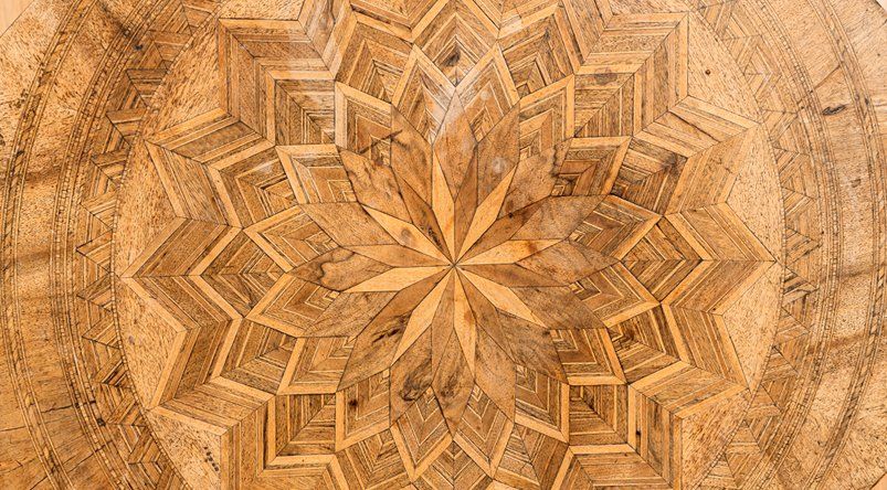 A close up of a wooden cutting board with a circular pattern on it.