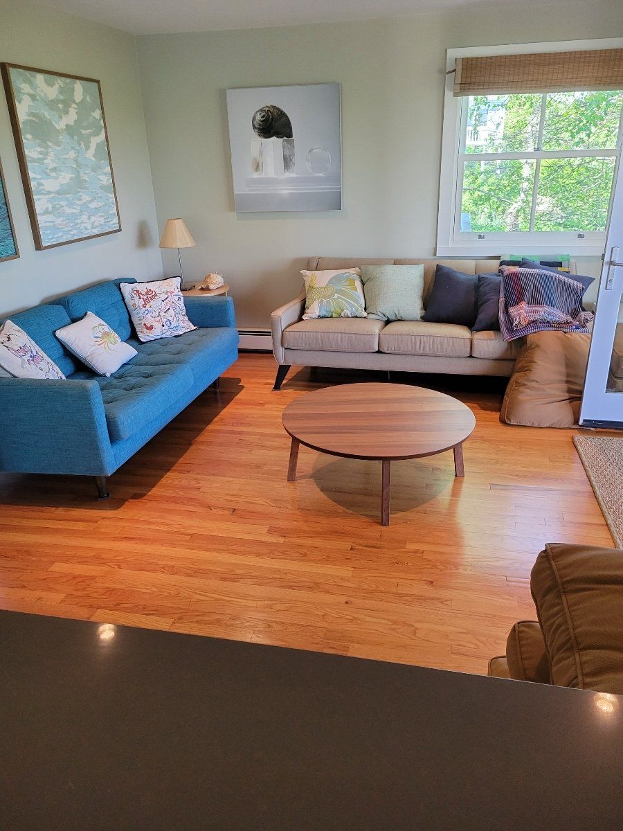 A living room with a blue couch and a round coffee table.