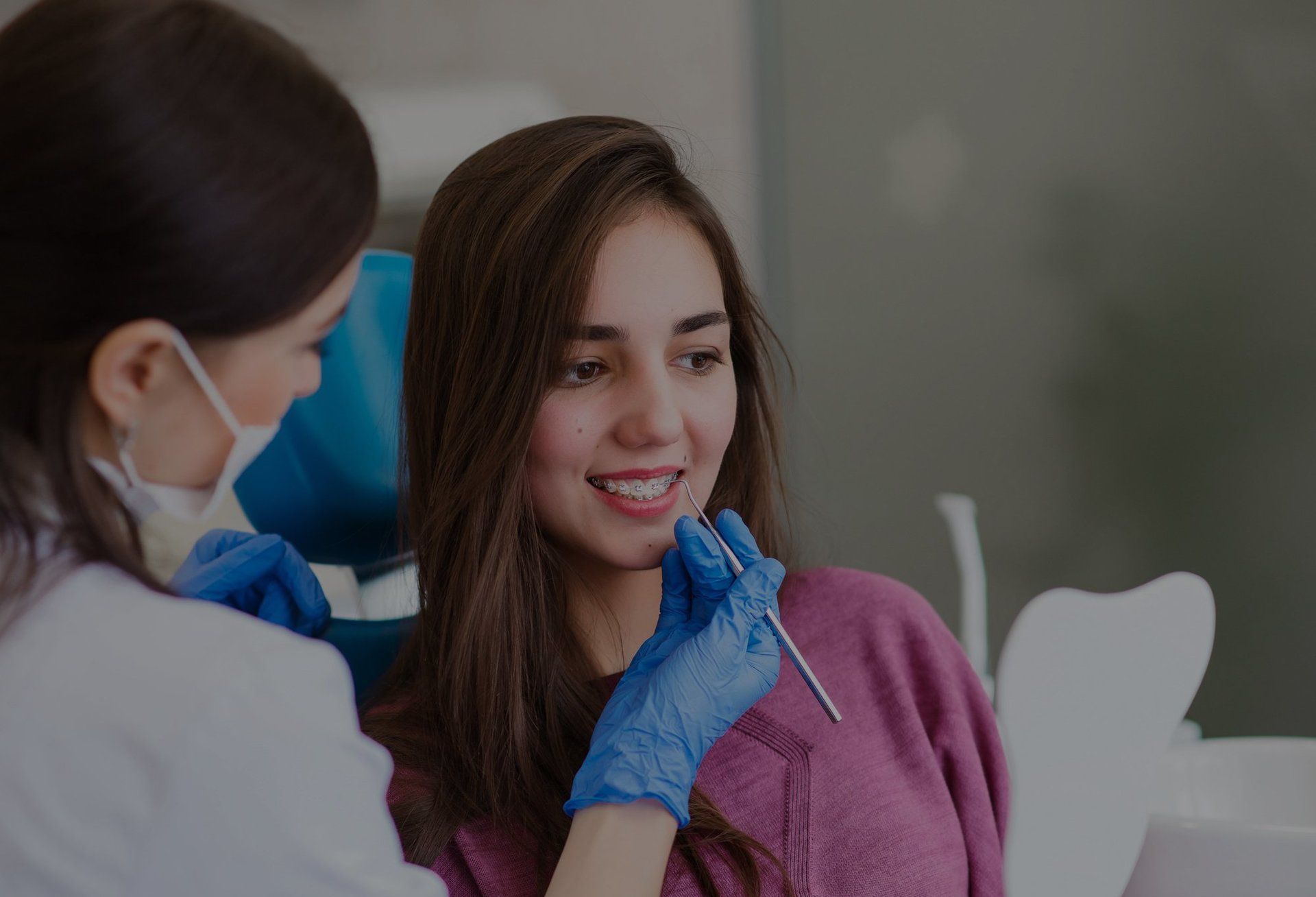 Beautiful girl with dental braces at the reception at the dentist.