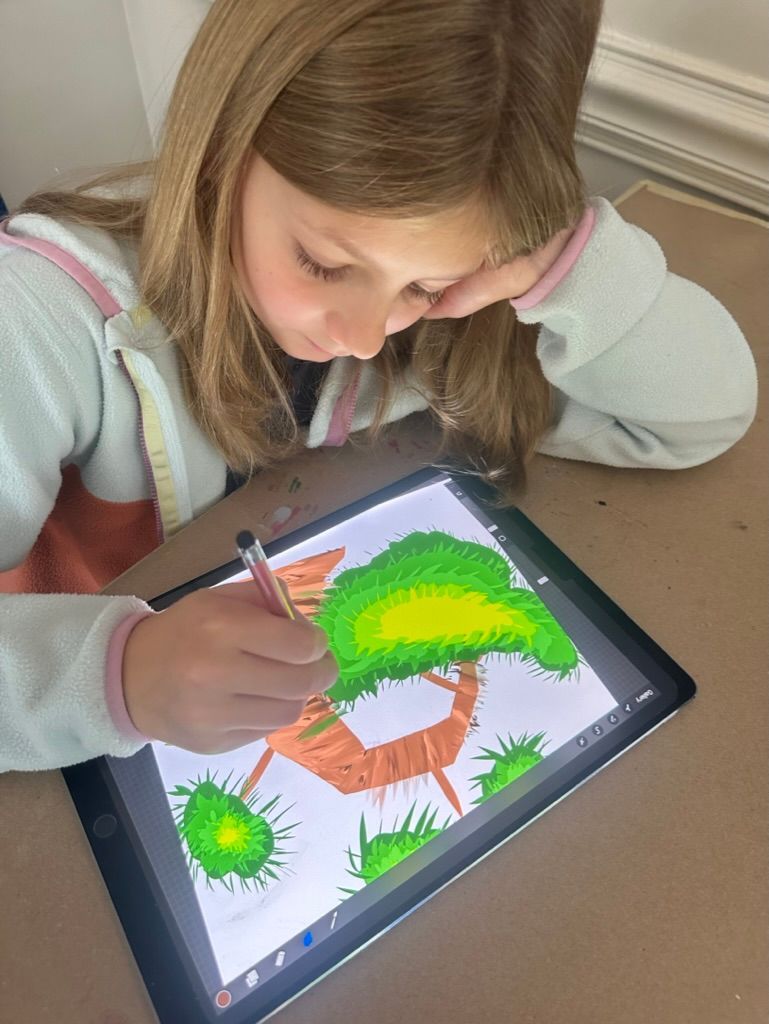 Girl drawing a treehouse on a tablet using a stylus. The drawing is colorful. She is leaning on her arm.