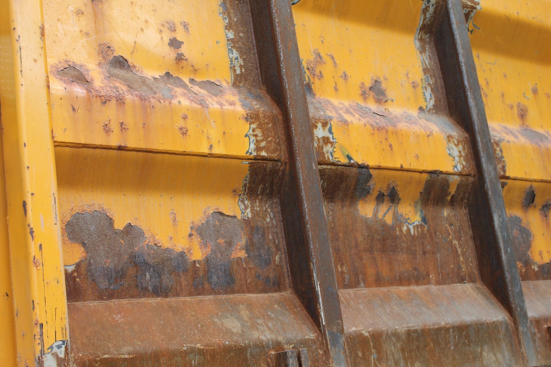 A close up of a rusty yellow metal object