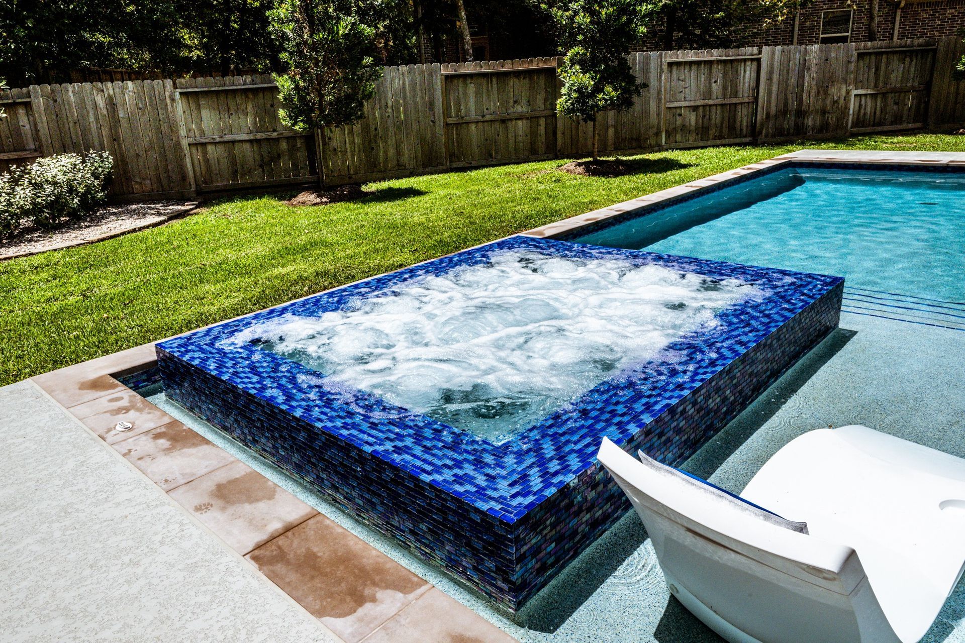A swimming pool with a jacuzzi in the middle of it.