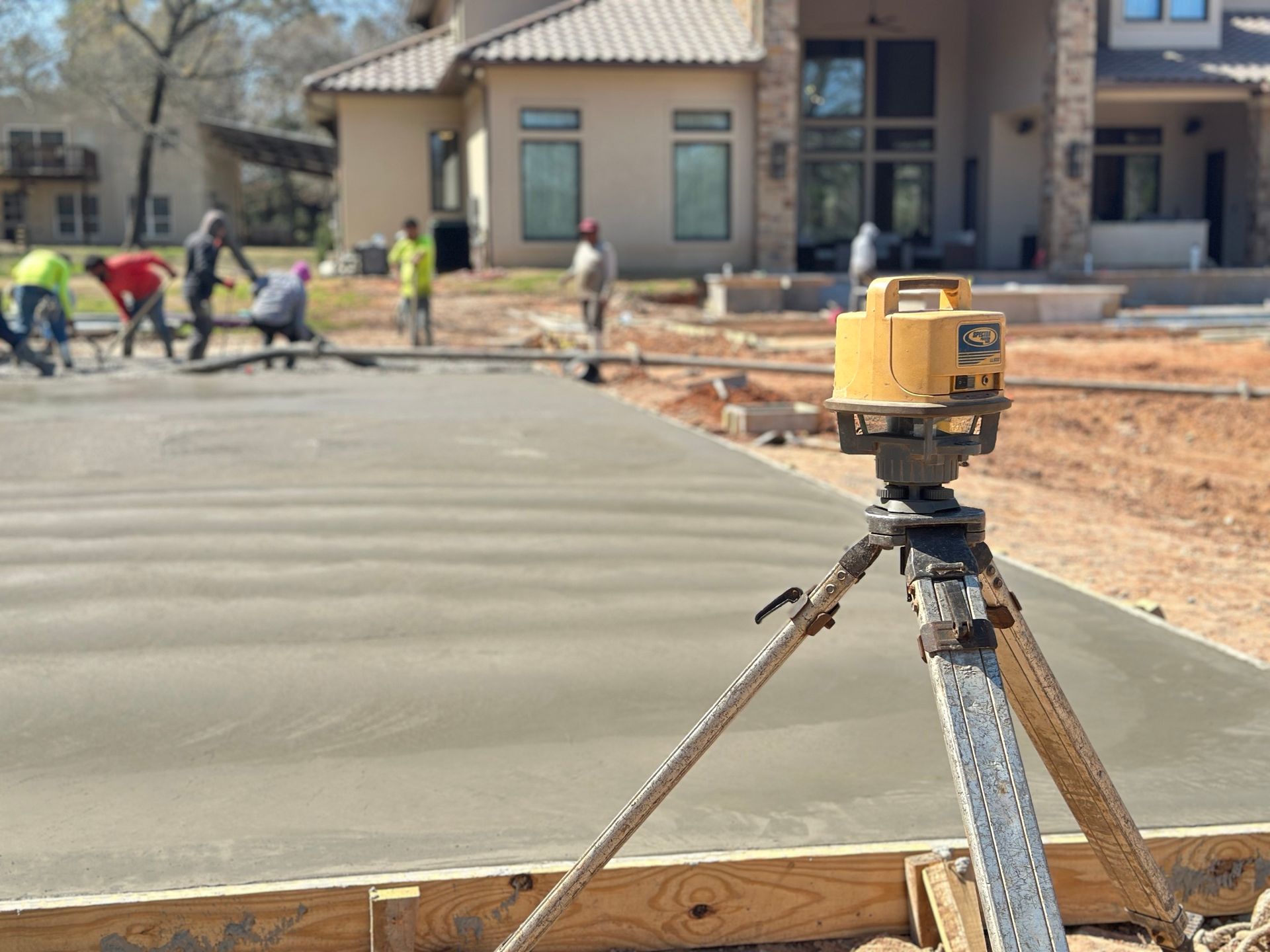 A concrete driveway is being built in front of a house.