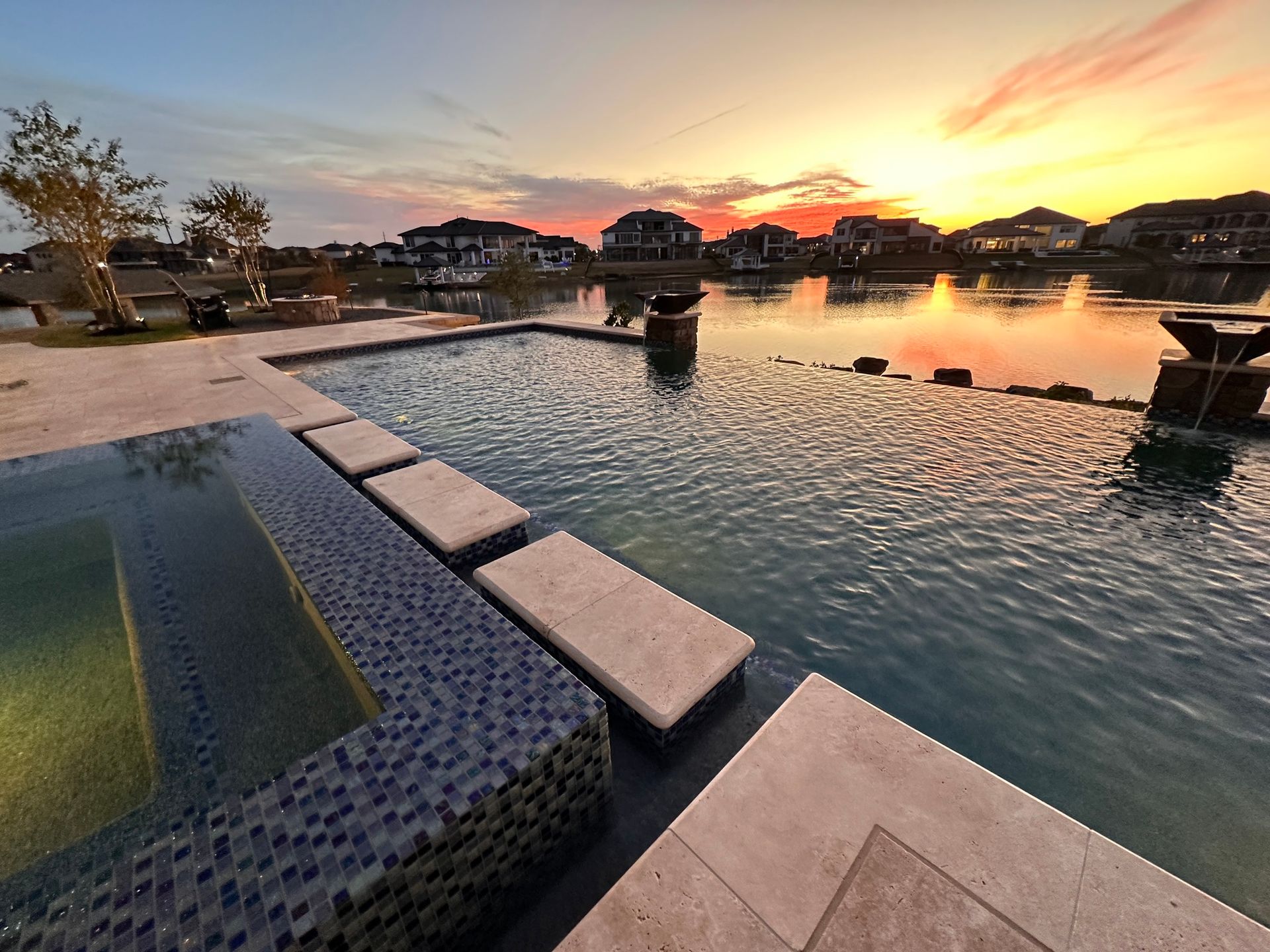 A large swimming pool with a sunset in the background