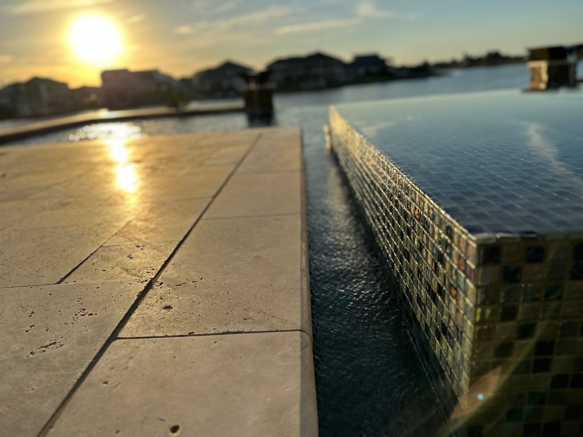 A swimming pool with a sunset in the background