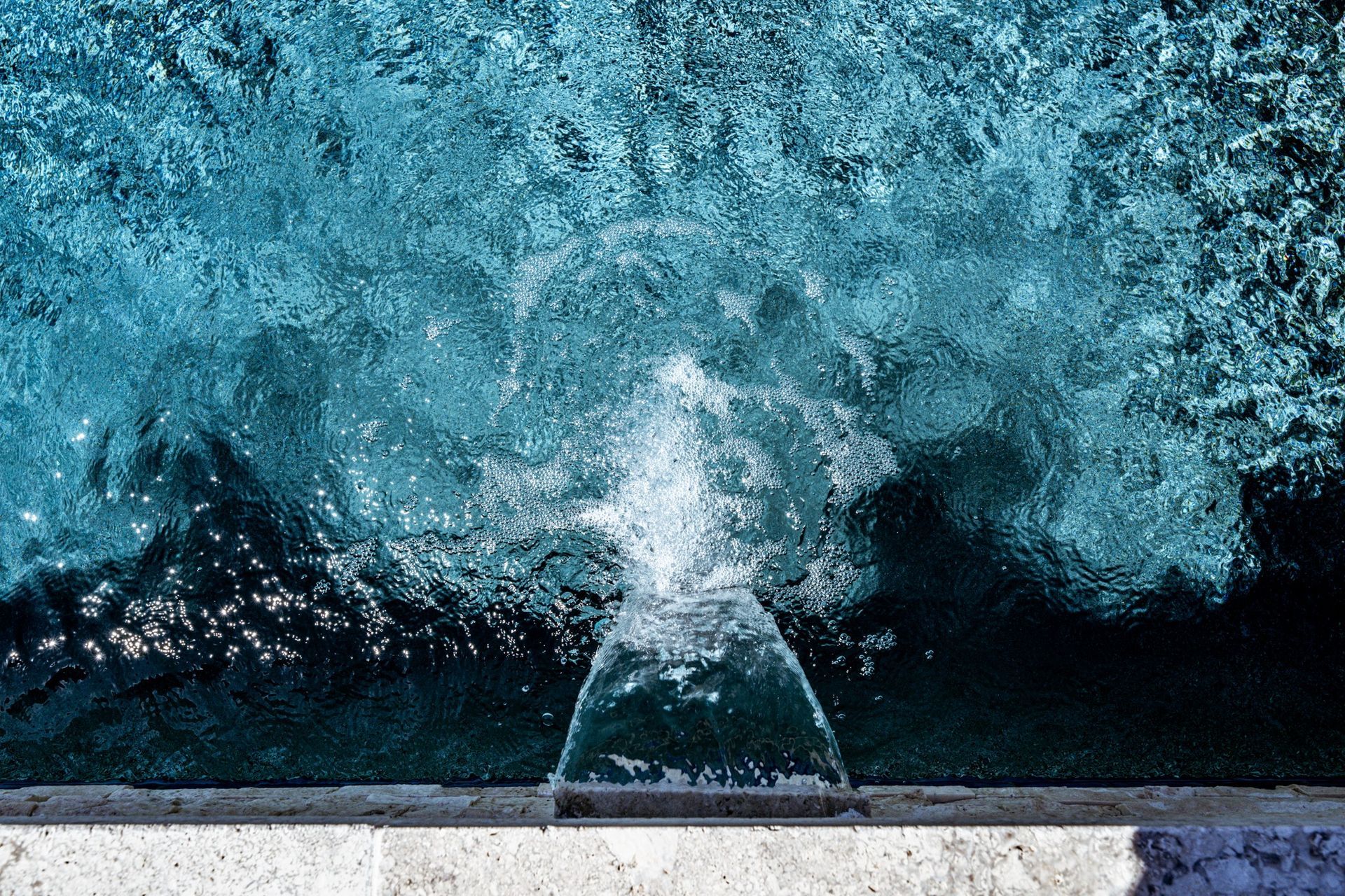 A fountain is spraying water into a pool of water.
