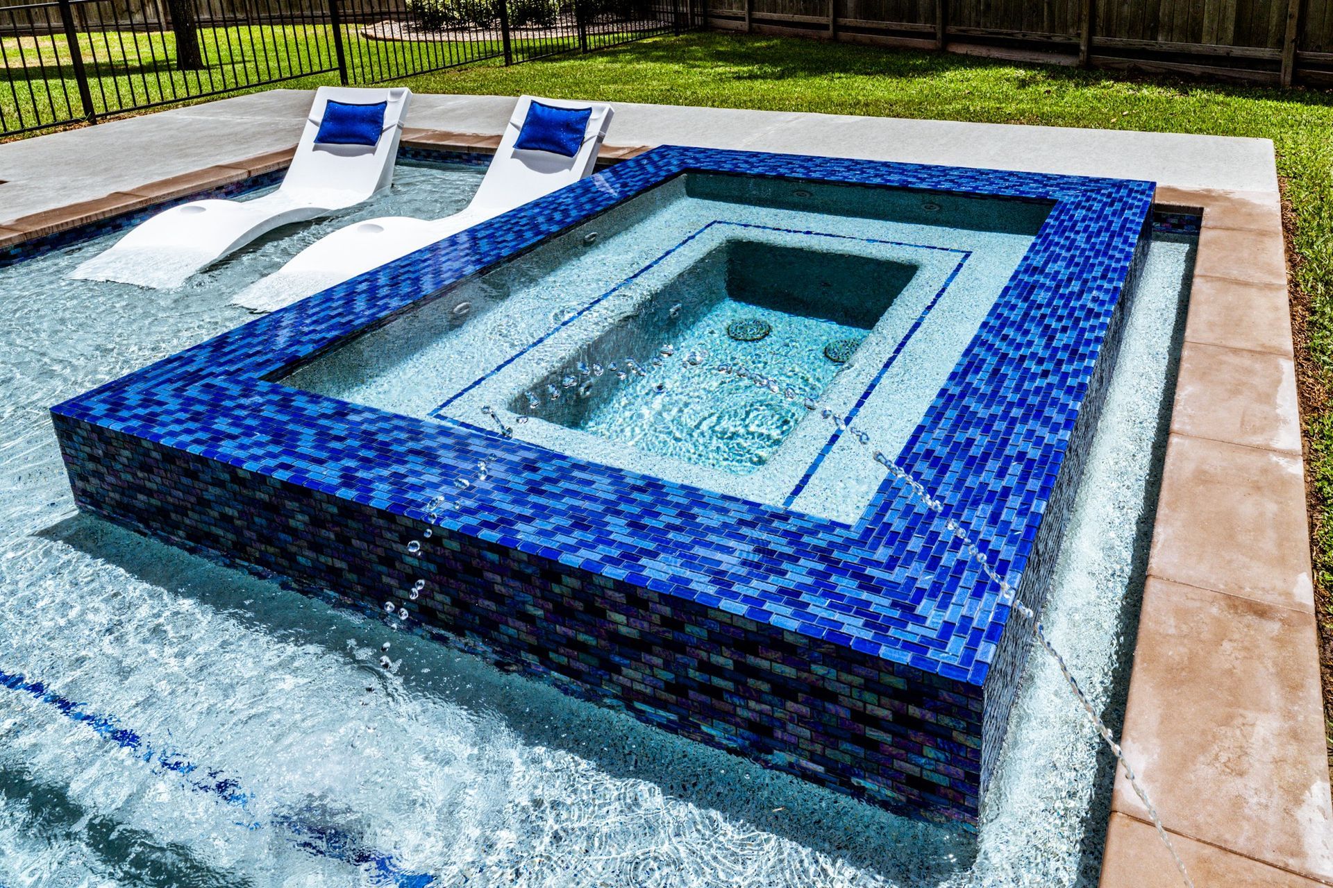 A swimming pool with a hot tub in the middle of it.