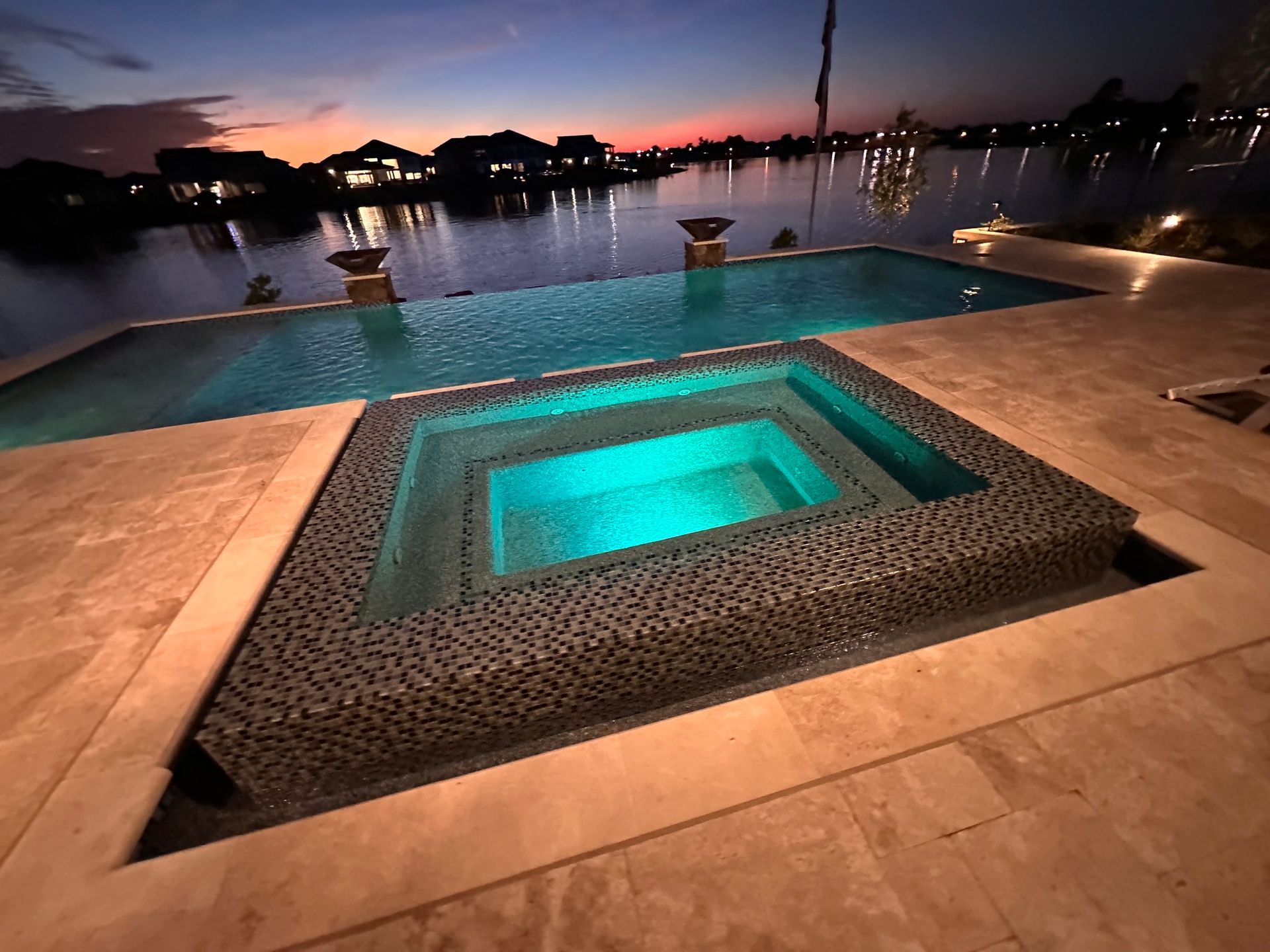 A swimming pool with a hot tub in the middle of it