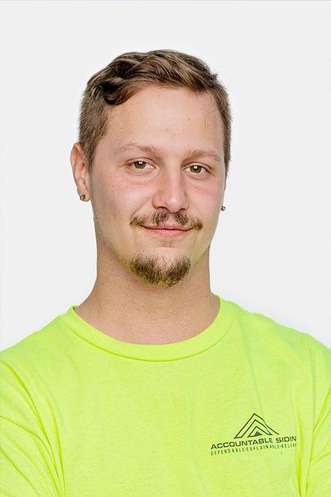 A man with a beard is wearing a neon yellow shirt.
