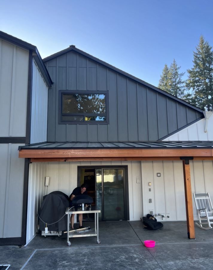 A man sits on a table outside of a house