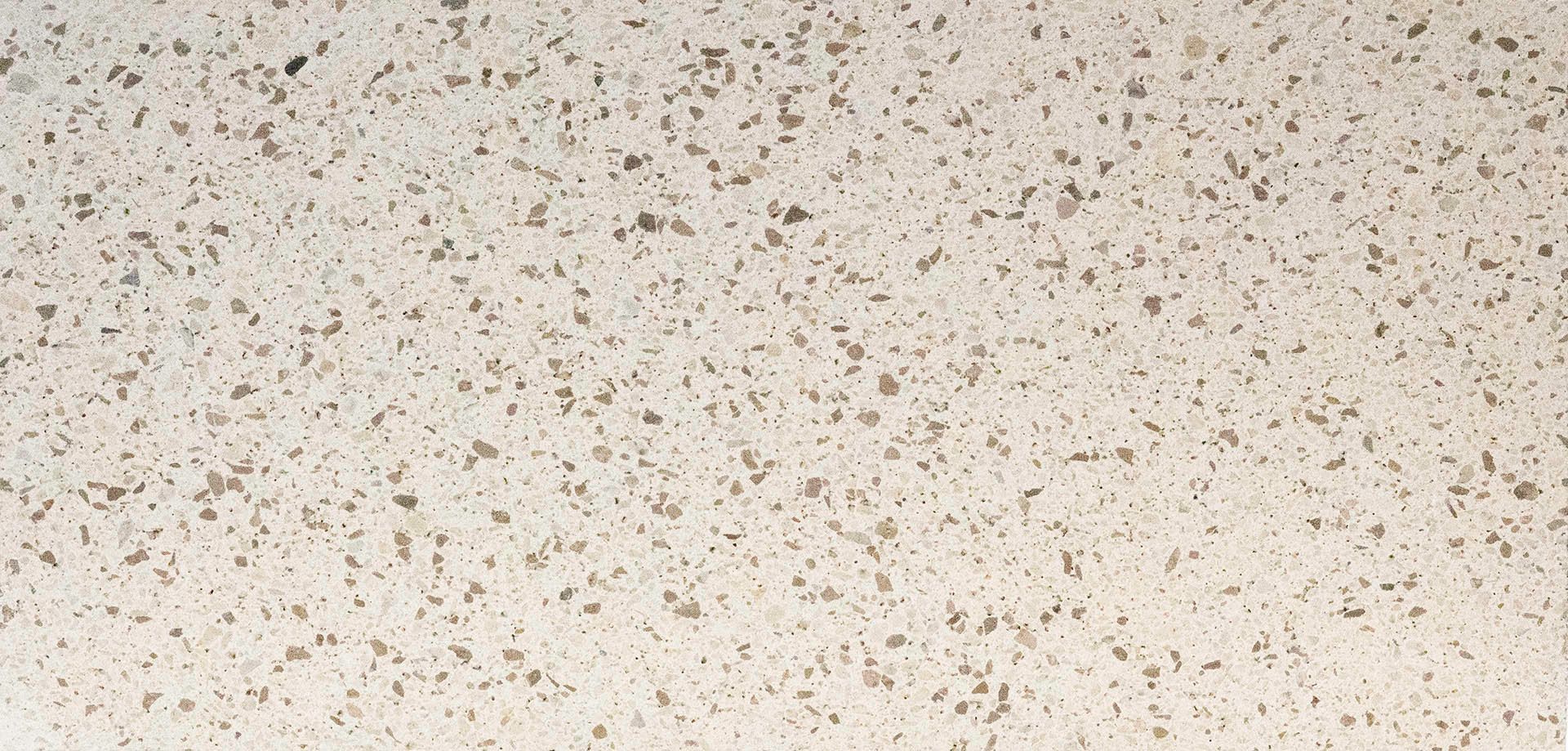 Close-up of a white speckled surface with small brown and gray flecks.
