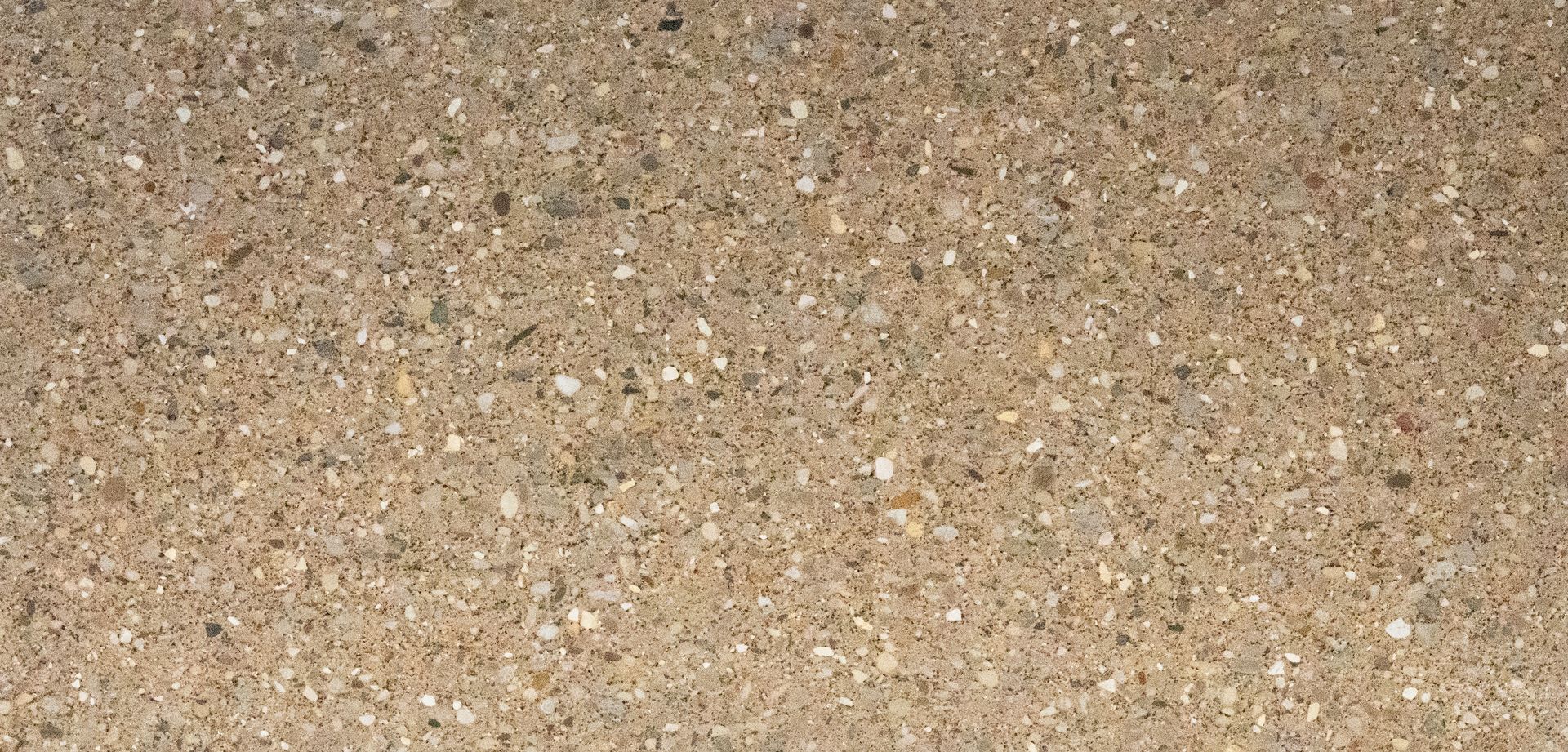 Close-up of beige and tan sand with small pebbles and speckled texture