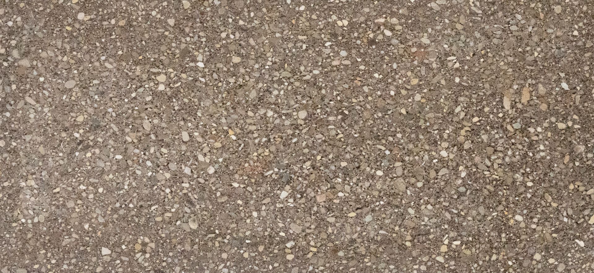 Close-up of speckled brown and beige gravel or textured stone surface