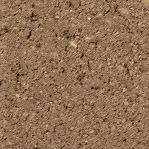 Close-up of brown, textured earth with small particles and uneven surface.