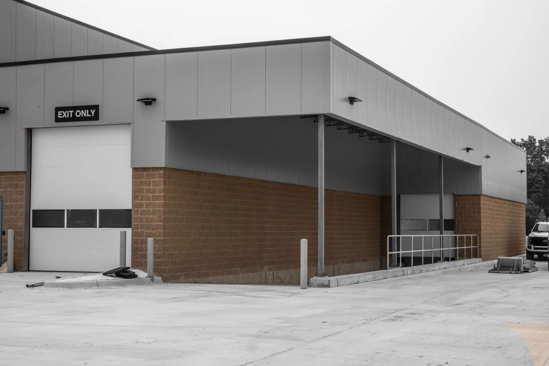 Loading dock area, tan brick and silver metal building exterior with ramp and 