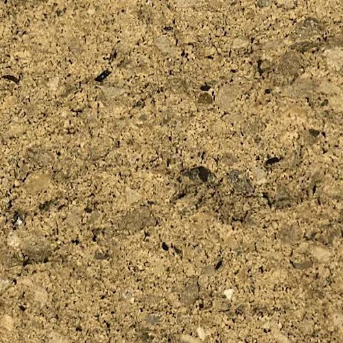 Close-up of a rough, light-brown textured surface with small stones embedded in it.