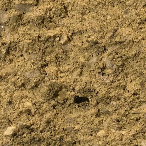 Close-up view of textured, light brown gravel with small, light-colored stones.