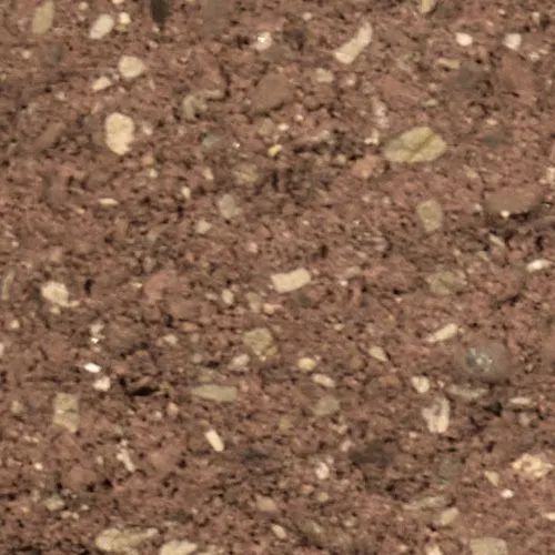 Close-up of rough red-brown material with embedded small stones and particles of various colors.