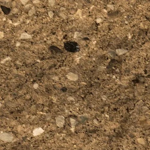 Close-up of brown, textured surface with small, speckled stones embedded throughout.