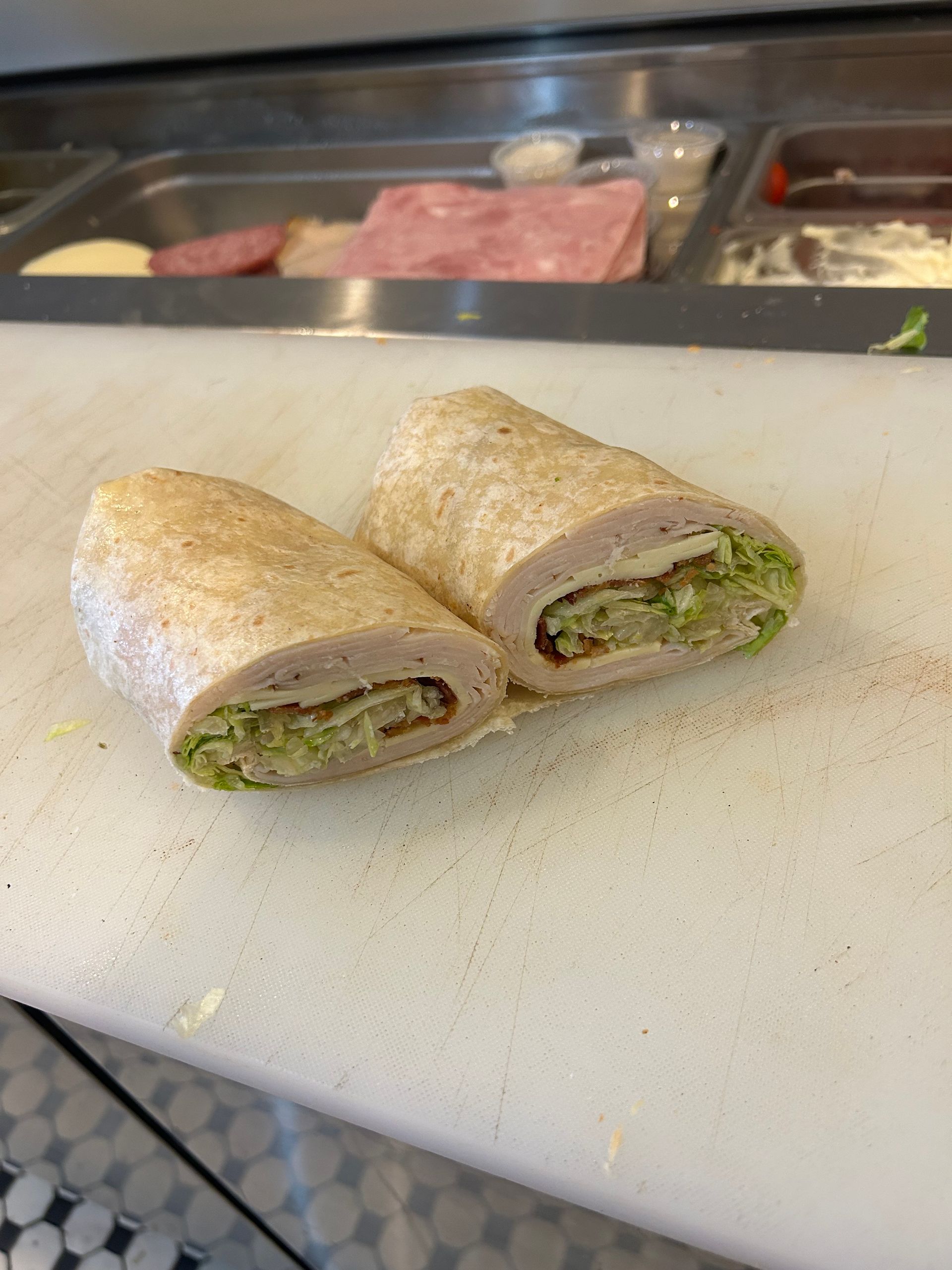 A sandwich is cut in half on a cutting board.